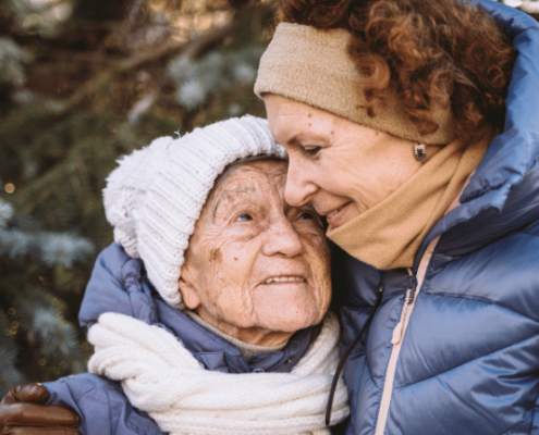 Mother hugging elder mother during winter