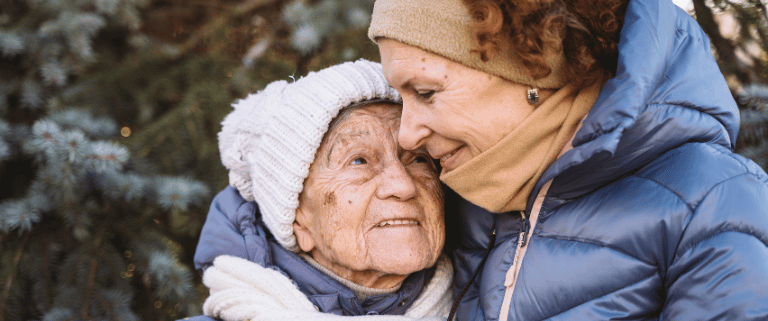 Mother hugging elder mother during winter