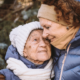 Mother hugging elder mother during winter