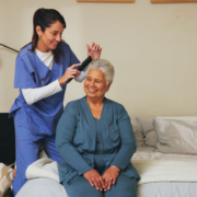 senior women getting her hair brushed by home health aide.