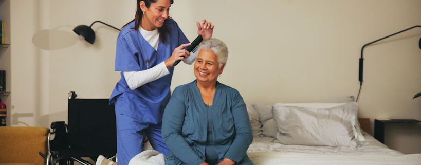 senior women getting her hair brushed by home health aide.